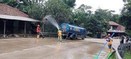 PT. Sino Sigap Bersihkan Tanah Yang Berceceran di Jalan Cinangis-Gunung Cangri Dengan Cara Menyiram