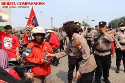 Aksi Humanis Polres Pelabuhan Tanjung Priok Bagikan Minum dan Roti Saat Buruh Rayakan May Day