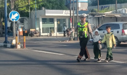 ​Wujud Polri Humanis, Personel Satlantas Polres Sampang Bantu Siswa SDN Gunung Sekar 1 Menembus Kemacetan