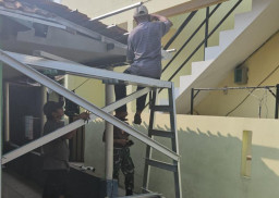 Babinsa Bersama Warga Gotong Royong Pasang Genteng untuk Pembangunan Rumah.
