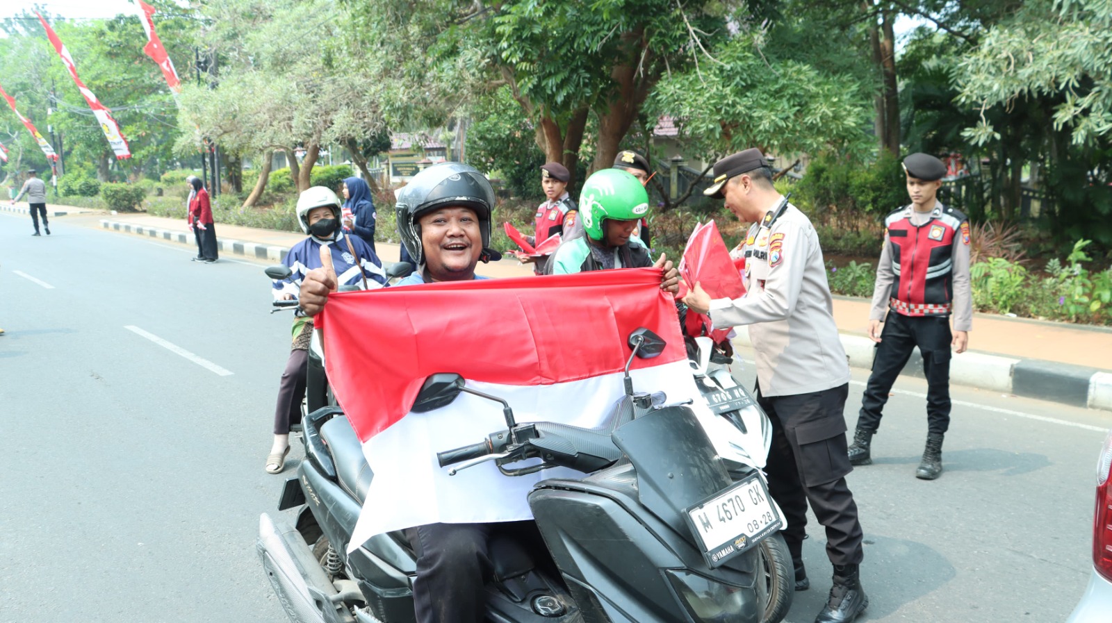 Dorong Semangat Nasionalisme, Kapolres Bangkalan Bagi-Bagi Bendera Merah-putih Kepada Pengendara Jalan
