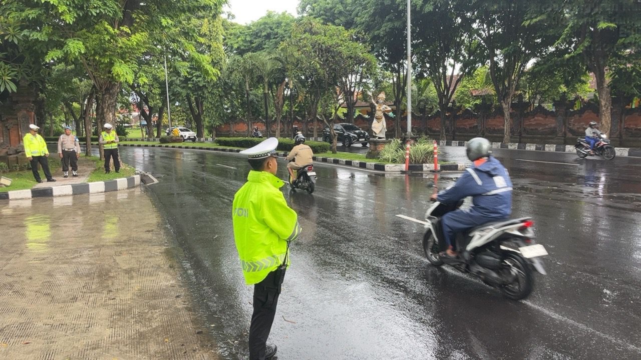 Tetap Lancar di Tengah Hujan: Polisi Bandara Ngurah Rai Kawal Arus Kendaraan Menuju Bandara
