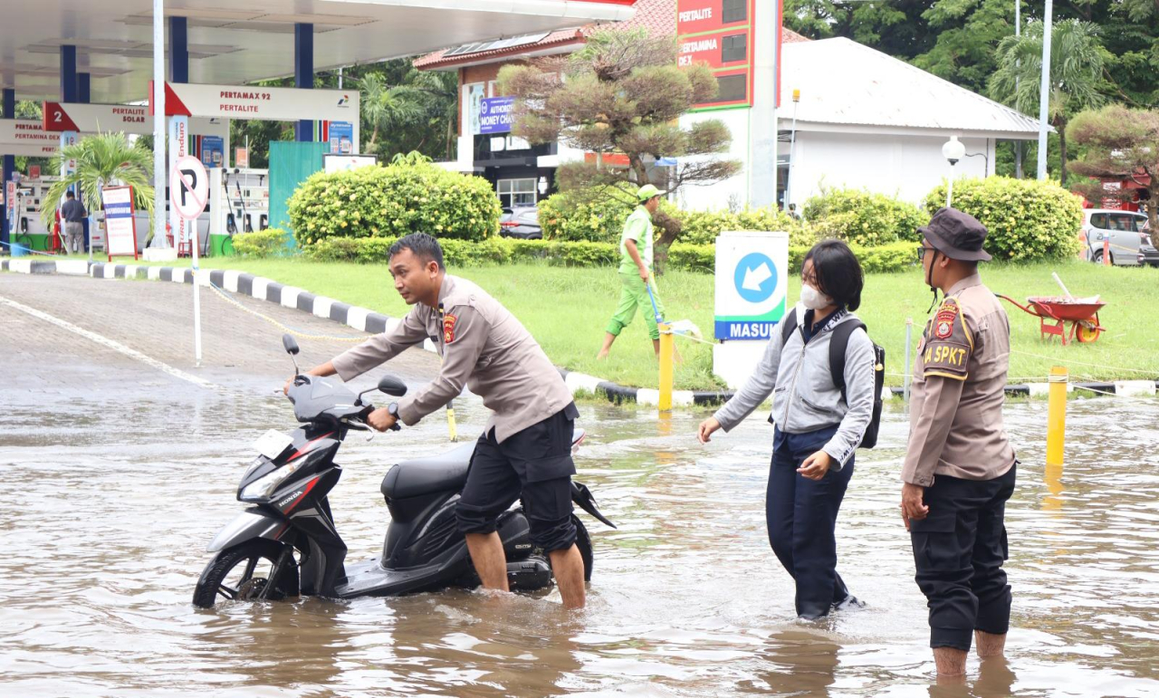 Polres Bandara Ngurah Rai Sigap Bantu Warga Terjebak Genangan Air di Depan SPBU
